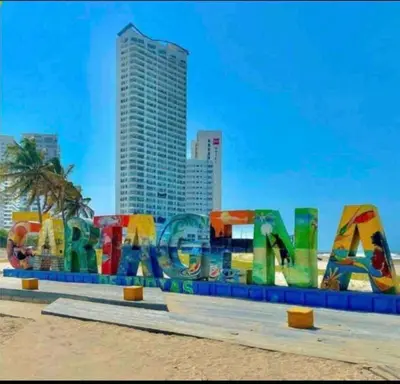 a sign on the beach with a city in the background at Luxury CTG Condo Near Beach Cold AC & Hot Water in Cartagena de Indias