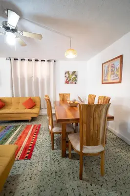 a dining room with a table and chairs and a couch at Casa Caribe, excellent location in Bocagrande in Cartagena de Indias