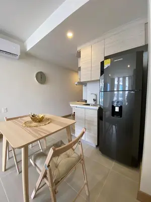 a kitchen with a table and a black refrigerator at Hermoso y acogedor Monoambiente in Cartagena de Indias