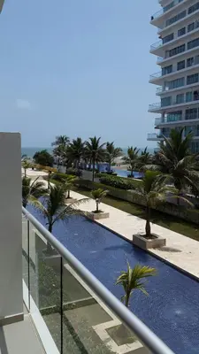 a view of a swimming pool with palm trees and a building at Morros Epic Cartagena in Cartagena de Indias