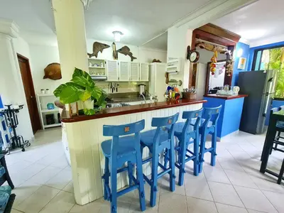 a kitchen with blue stools at a kitchen counter at Lujosa cabana con piscina playa y servicio in San Silvestre