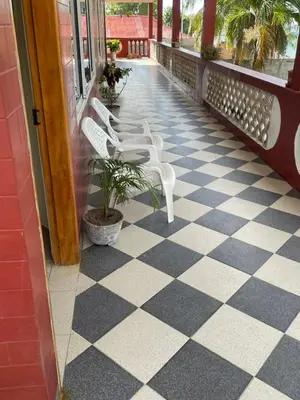 two white benches on a porch with a checkered floor at Las Margaritas Frente al Mar 2 in Coveñas