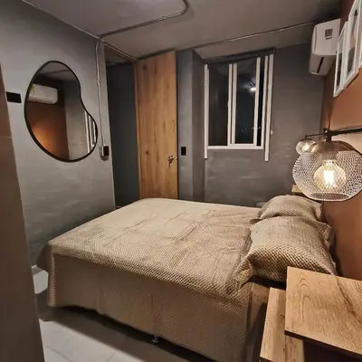 a small bedroom with a bed and a mirror at Exclusive apartament near downtown and beach in Cartagena de Indias