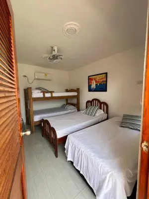 a bedroom with two beds and a table in it at Asís apartamentos in Tolú