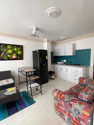 a living room with a couch and a kitchen at Asís apartamentos in Tolú