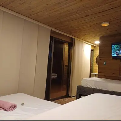 a room with two beds and a tv on the wall at Alta vista Turbaco in Cartagena de Indias