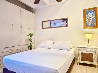 a white bedroom with a bed and a mirror at Apartamento Caribe Hilton View - Piso 7 in Cartagena de Indias