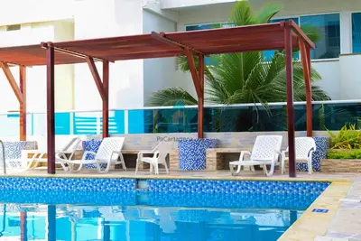 a pool with chairs and a gazebo next to a swimming pool at Apartamento Caribe Hilton View - Piso 7 in Cartagena de Indias