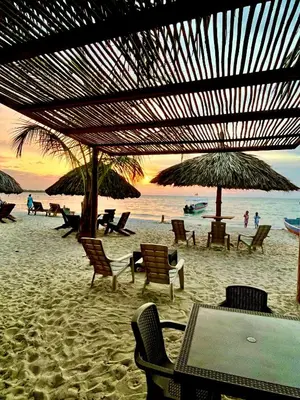 a beach with chairs and umbrellas and the ocean at Aquarius Diving Club y Cabañas in Rincón