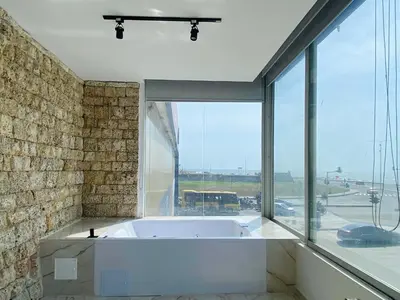 a bath tub in a room with a large window at Muralla by Wynwood House in Cartagena de Indias