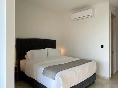a bedroom with a white bed with a black headboard at Muralla by Wynwood House in Cartagena de Indias