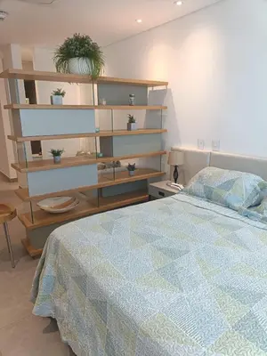 a bedroom with a bed and a book shelf at Suite 803 Edif Distrito 90 in Barranquilla