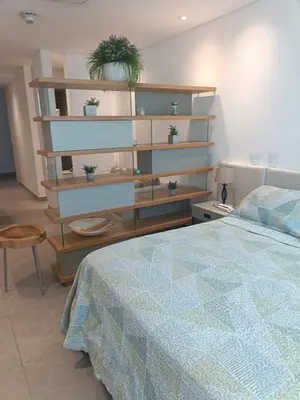 a bedroom with a bed and a shelf with potted plants at Suite 803 Edif Distrito 90 in Barranquilla