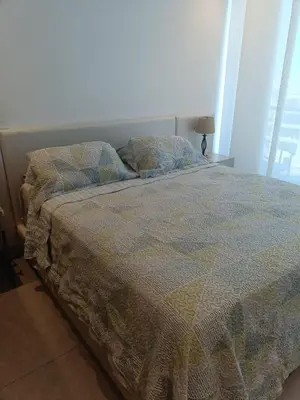 a bed with a quilt and pillows in a bedroom at Suite 803 Edif Distrito 90 in Barranquilla
