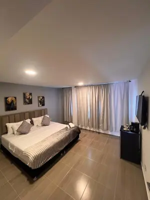 a bedroom with a large bed and a flat screen tv at Davé Paradise in Cartagena de Indias