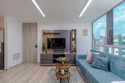 a living room with a blue couch and a tv at Lux University Apt in Barranquilla