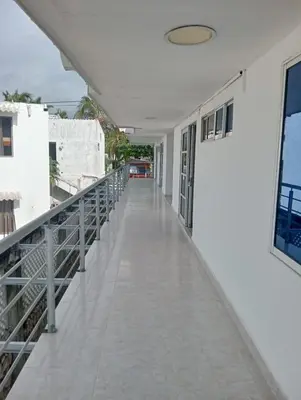 a corridor of a white building with a balcony at CABAÑAS CALIPSO, 2 piso in Coveñas