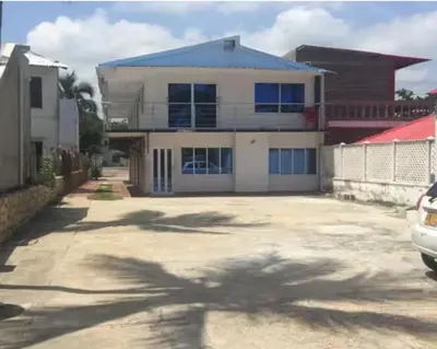 a house with a car parked in front of it at CABAÑAS CALIPSO, 2 piso in Coveñas