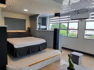 a bedroom with a bed and a couch and windows at Studio Apartment Old City Cartagena Almirante in Cartagena de Indias