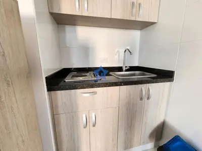 a small kitchen with wooden cabinets and a sink at Apartamento Piso 18 Blue Horizon in Cartagena de Indias