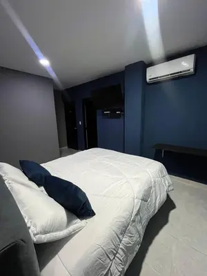 a bedroom with a white bed with blue walls at Hotel Villa Marta Cartagena in Cartagena de Indias