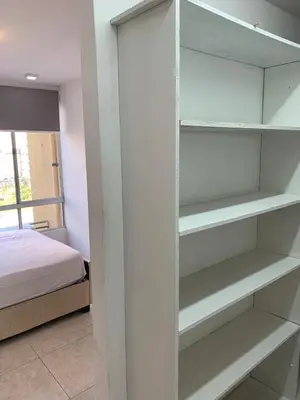 a room with a bed and a closet with shelves at Apartamento acogedor in Barranquilla