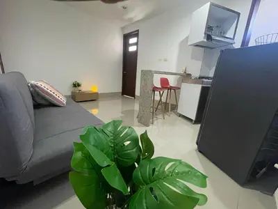 a living room with a couch and a kitchen at Excelente apartaestudio in Sincelejo