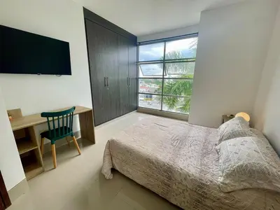 a bedroom with a bed and a desk and a window at Excelente apartaestudio in Sincelejo