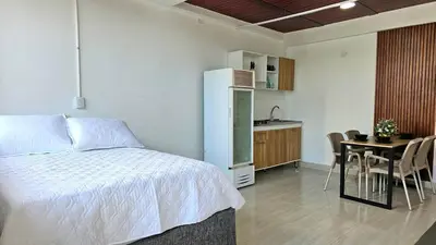 a bedroom with a bed and a table and a kitchen at Apartamento cerca a la playa y al mar Punta Roca in Maizal