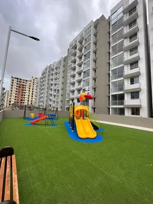 a playground with a slide on a lawn in front of a building at Apto con vista verde y aire acondicionado in Barranquilla