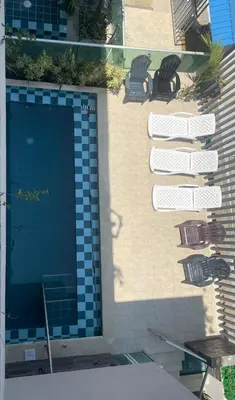 a swimming pool with two chairs and a building at Terraza Del Sol in Coveñitas