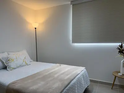 a bedroom with a bed and a window with a blind at Cozy and close to the airport in Cartagena de Indias