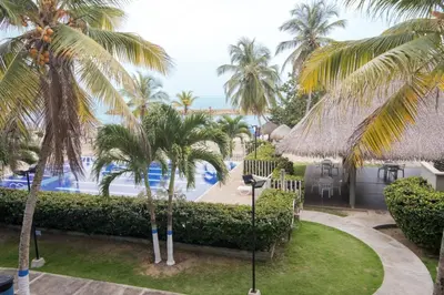 a view of a resort with palm trees and a swimming pool at Hermoso Apartamento Frente al Mar 2 Habitaciones PAZ127 in Coveñas