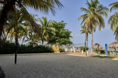 a park with palm trees and a building at Hermoso Apartamento Frente al Mar 2 Habitaciones PAZ127 in Coveñas