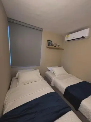 two beds in a small room with a window at Apartment in Alameda del Río in Barranquilla
