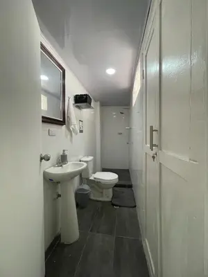 a white bathroom with a toilet and a sink at Homethel Studio Apt privado in Cartagena de Indias