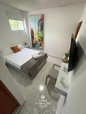 a bedroom with a bed and a tv and a table at Casa Corales Cartagena in Cartagena de Indias