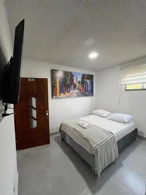a bedroom with a bed and a flat screen tv at Casa Corales Cartagena in Cartagena de Indias