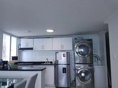 a kitchen with a refrigerator and two washer and dryer at Espectaculares Vistas, Edificio Nautilus, Barrio El Laguito. in Cartagena de Indias