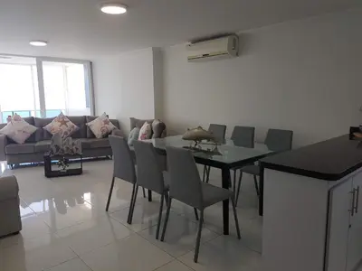 a living room with a couch and a table and chairs at Espectaculares Vistas, Edificio Nautilus, Barrio El Laguito. in Cartagena de Indias