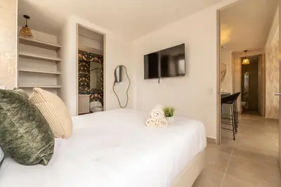 a bedroom with a white bed and a flat screen tv at Apartment with a Pool and Parking 2Bed in Cartagen in Cartagena de Indias