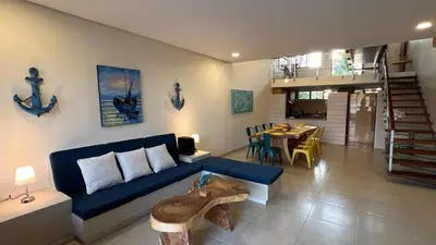 a living room with a blue couch and a table at Exclusive Loft in Barú, access by sea and land in Isla Barú