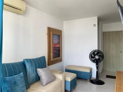 a living room with a blue couch and a fan at Amoblado cerca playa Marbella in Cartagena de Indias