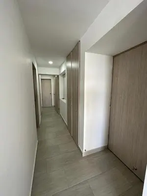 an empty hallway with white walls and wooden doors at Apartamento Moderno con Piscina en el Laguito in Cartagena de Indias