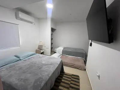 a bedroom with two beds and a tv on the wall at Holtalia in Santiago