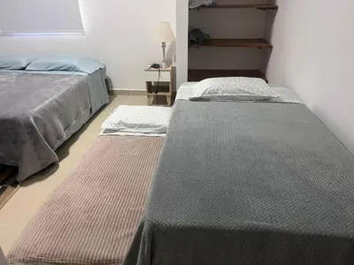 a room with two beds and a table with a lamp at Holtalia in Santiago