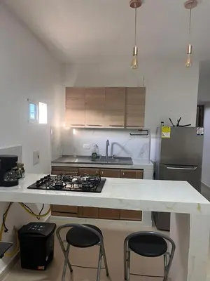 a kitchen with a stove and three stools in it at Holtalia in Santiago