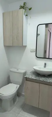 a bathroom with a toilet and a sink and a mirror at EntreLagos Family Suite Vista a la Ciudad in Cartagena de Indias
