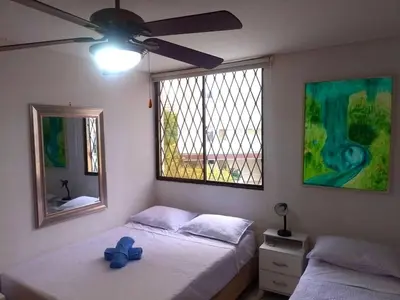 a bedroom with two beds and a ceiling fan at Bello Horizonte y CC ZAZUE in Santa Marta