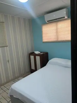 a bedroom with two white beds and a blue wall at Beach Airport House in Cartagena de Indias